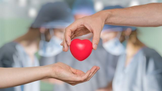 Corazón frente a un grupo de cirujanos operando en quirófano