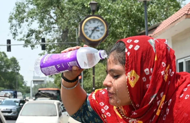 인도 델리에서 한 여성이 더위를 식히기 위해 얼굴에 물을 붓고 있다