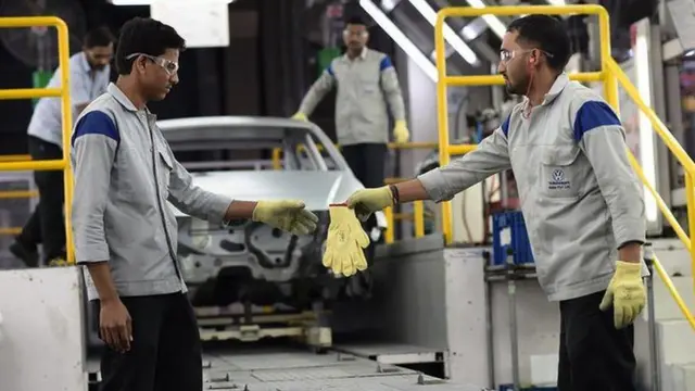फोक्सवॅगन पुणे प्लांटमध्ये काम करताना कर्मचारी