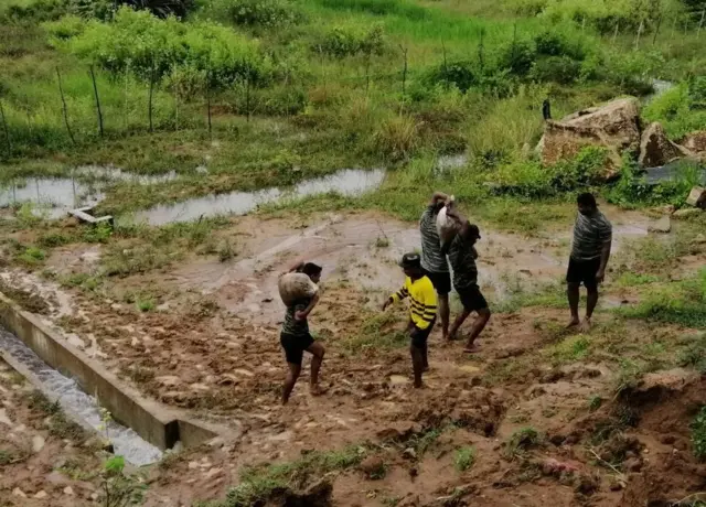 හානියට පත් වැව් බැම්මක් ආරක්ෂා කිරීම සඳහා කටයුතු කරන ආරක්ෂක හමුදා සාමාජිකයන්