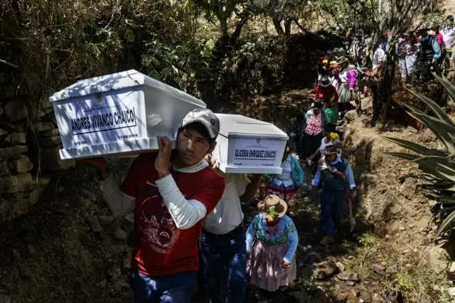 Deudos llevan en hombros los restos de sus familiares hacia el cementerio comunal de Uchu. (Foto: Ángela Ponce).