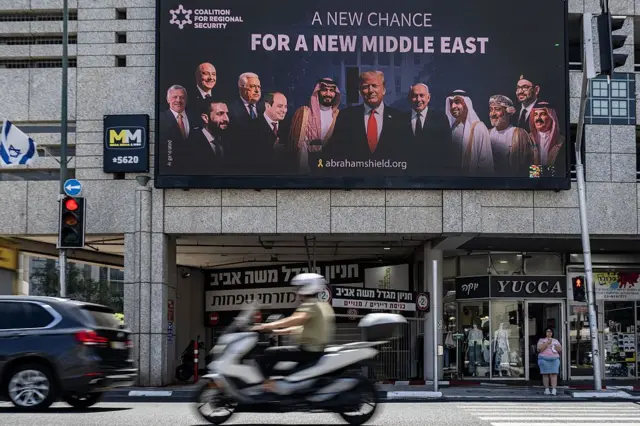 پوستر بزرگی که تصویر رهبران عربستان سعودی، سوریه، عمان و لبنان را در کنار دونالد ترامپ، رئیس‌جمهور آمریکا، و بنیامین نتانیاهو، نخست‌وزیر اسرائیل، نشان می‌دهد، در ۲۶ ژوئن ۲۰۲۵ در تل‌آویو نصب شده است؛ پوسترهایی که بر تلاش‌ها برای گسترش روابط دیپلماتیک تأکید دارند.