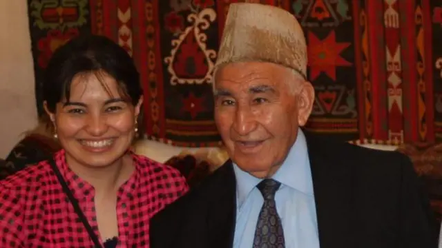زینب بادغیسی در کنار پدرش، محمدعوض بادغیسی است. هر دو مستقیم به کمره نگاه می‌کنند و لبخند بر لب دارند. زینب پیراهنی سرخ و سیاه خال‌دار بر تن دارد. پدرش کت‌وشلوار تیره همراه با نکتایی پوشیده و کلاه پوست بر سر دارد. در پس‌زمینه نیز چند قالین سنتی آسیای میانه دیده می‌شود.
