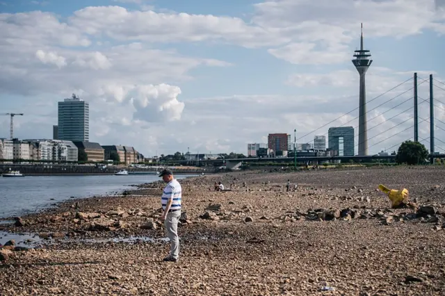 Bir adam, 5 Ağustos 2026'da Almanya'nın Düsseldorf kentinde Ren Nehri'nin kısmen kurumuş yatağına bakıyor.