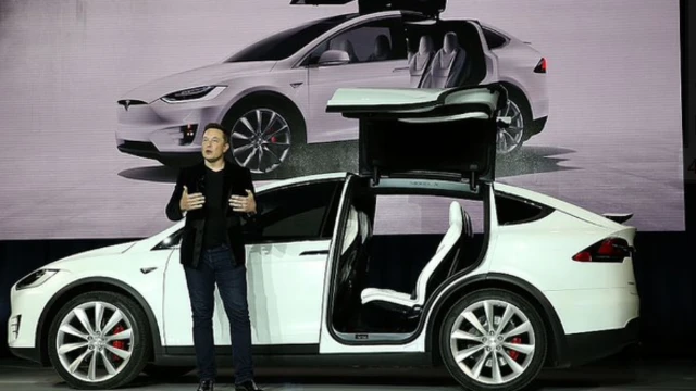 Elon Musk near a Tesla electric vehicle