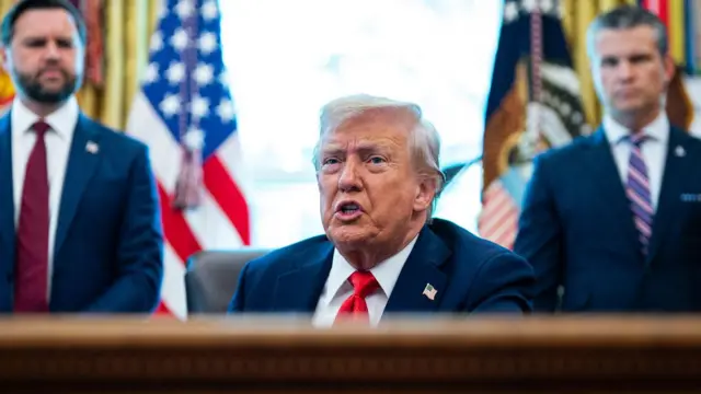 O vice-presidente dos EUA, JD Vance (à esquerda), o presidente Donald Trump e o secretário de Defesa dos EUA, Pete Hegseth, durante a assinatura de um decreto no Salão Oval da Casa Branca, em Washington D.C.