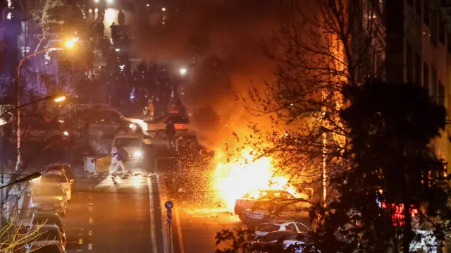 سيارات تحترق في أحد شوارع طهران، إيران