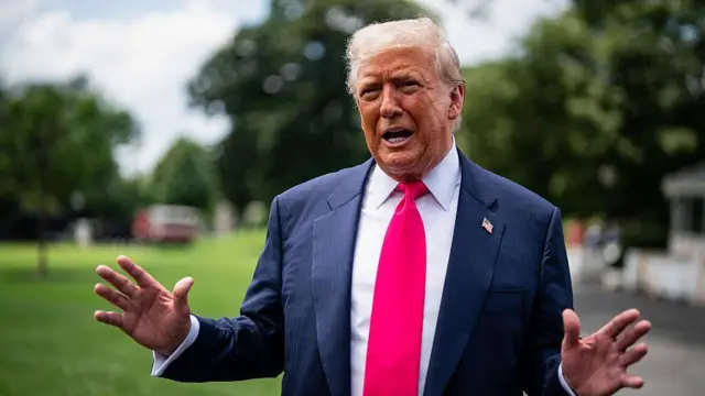 Trump gesticulando enquanto fala, sentado