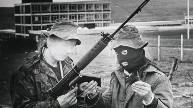 مجندة مقنعة في الجيش الجمهوري الإيرلندي تتلقى تدريباً على استخدام السلاح في لندنديري في السبعينيات