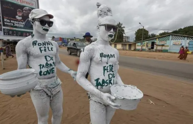 Deux hommes à Abidjan ont peint "Joyeux Eid" sur leur poitrine.