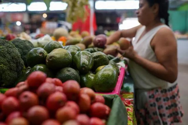 Mujer ordena frutas en una feria