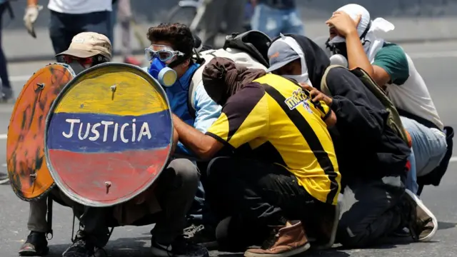 Opositores cubriéndose de los gases.