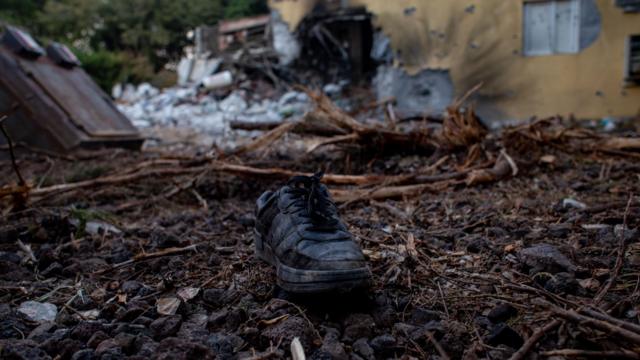 Sebuah sepatu bot tergeletak di tanah di luar rumah yang rusak di Be'eri, Israel, 11 Oktober 2023.