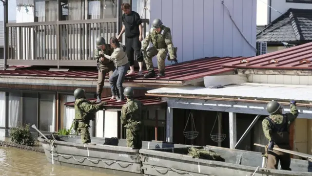 Japanese soldiers use boats to help people in heavy floods