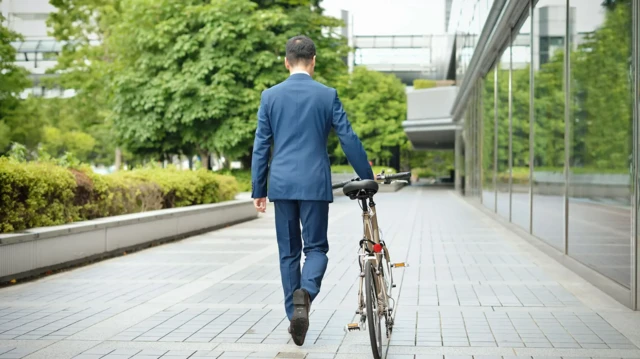 ایک شخص سائیکل پر کام چھوڑ کر جا رہا ہے