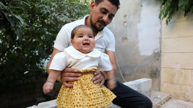 Bebê Afraa sorrindo com seu tio