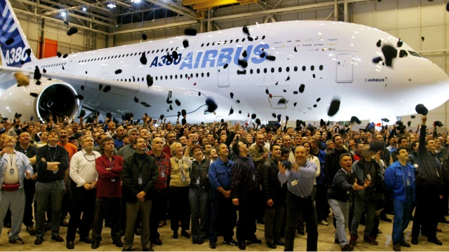 空中巴士員工在新款A380超級巨無霸飛機的揭幕儀式上，將帽子拋向空中
