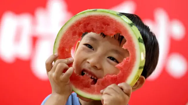 ትንሽ ልጅ ሀብሀብ እየበላ