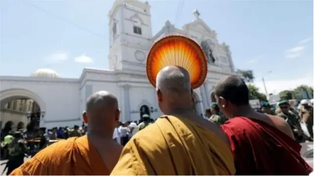 সেন্ট অ্যান্থনি গির্জার সামনে দাঁড়িয়ে আছেন বৌদ্ধ ভিক্ষুরা।