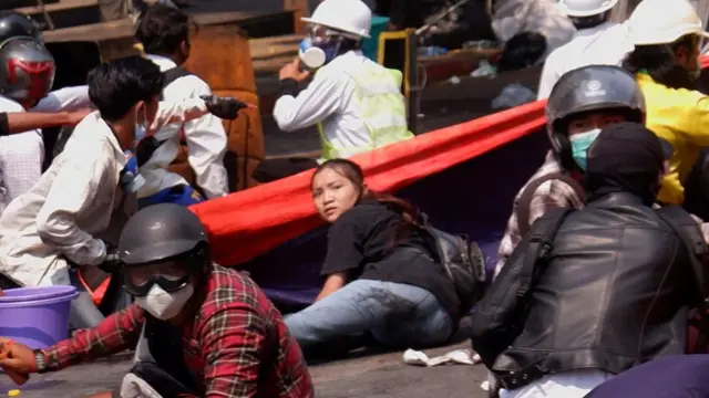 ဂျင်းဘောင်းဘီမိုးပြာရောင်နဲ့ တီရှပ်အနက်ဝတ်ထားသူမိန်းကလေးတယောက်ဟာ လက်ထောက်ပြီးဝပ်နေရာကနေ ကိုယ်ကိုလှိမ့်ပြီး နေရာရွှေ့လိုက်ပါတယ်