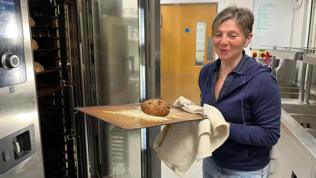 Mariella Giancola, a cook at the Rothera Research Station, takes a cake out of an oven
