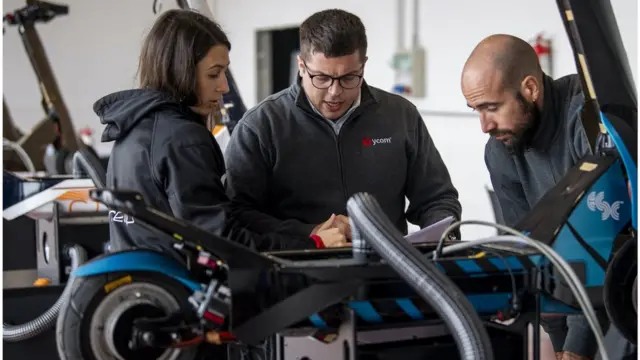 Des ingénieurs travaillent sur des scooters électriques de course