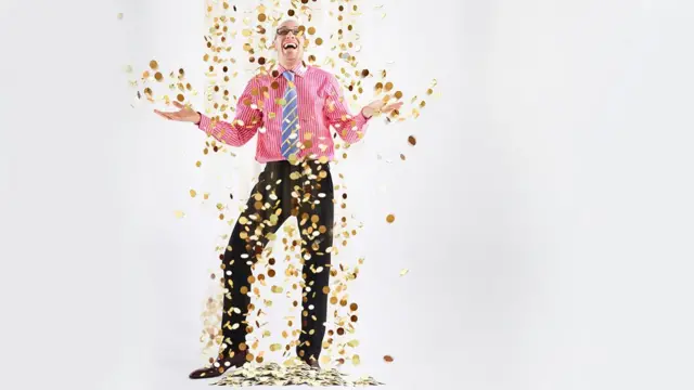 Hombre bajo lluvia de monedas.