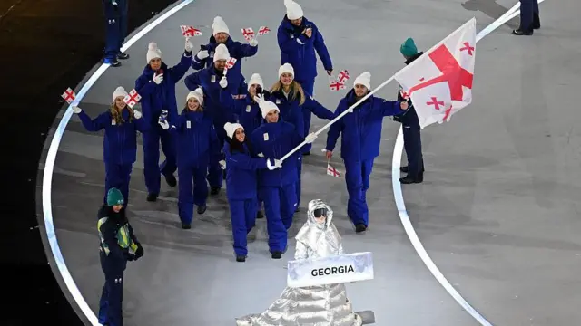 Знаменосцы Диана Дэвис и Лука Берулава несут флаг Грузии во время церемонии открытия зимних Олимпийских игр на стадионе «Сан-Сиро» 6 февраля 2026 года в Милане, Италия.