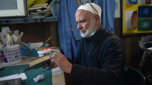 A Libyan volunteer repairs of Koran during the holy of month of Ramadan in Tripoli, Libya April 10, 2022. Picture taken April 10, 2022.