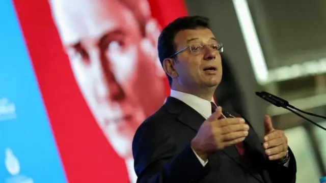 Ekrem İmamoğlu, Atatürk posteri önünde mikrofona konuşuyor