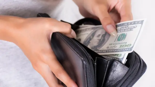 Mujer con dólares en la mano.