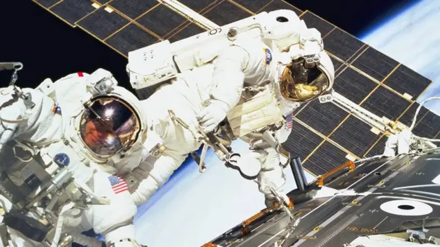 মহাশুন্যে ভেসে কাজ করছেন দু'জন অ্যাস্ট্রোনট।