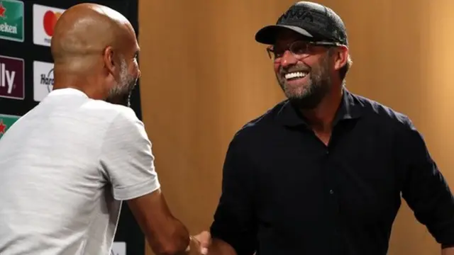 Mkufunzi wa Manchester City Pep Guardiola (kushoto) anaamkuana kwa mkono na mwenzake wa Liverpool Jurgen Klopp