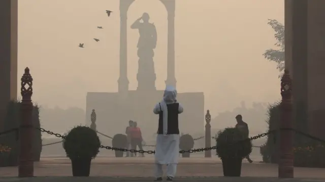 Женщина фотографирует памятник в Дели