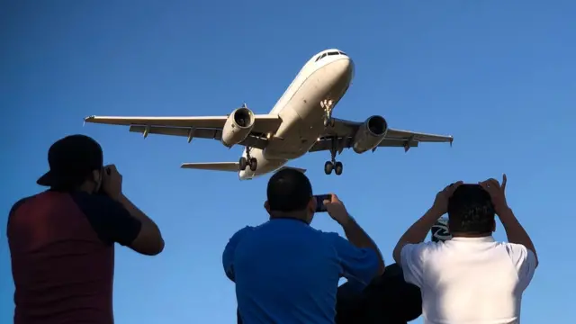 Homens olhando avião