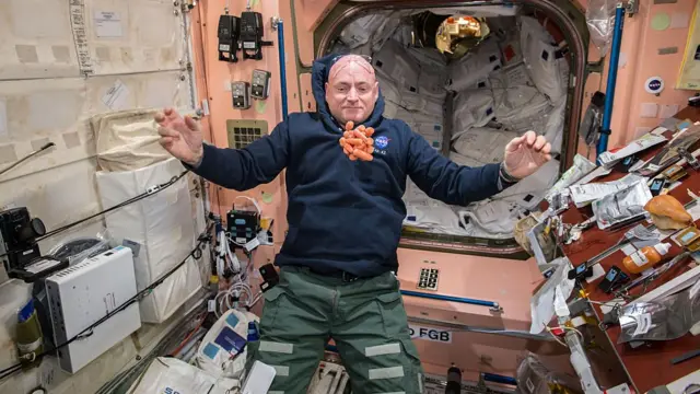 Astronauta tentando comer cenouras enquanto flutuam no espaço