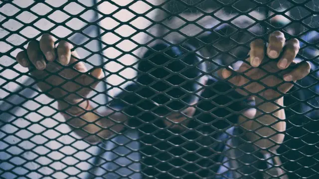 Hombre tras una reja.