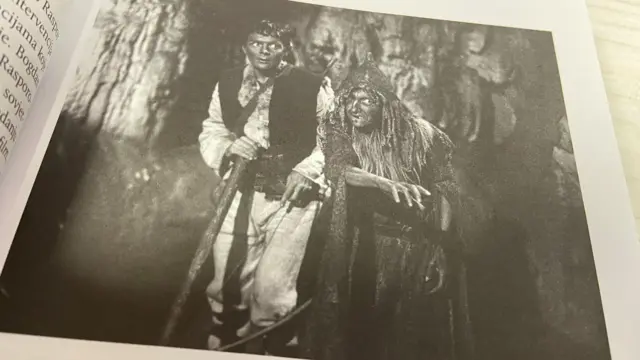 Фотографија на којој су мушкарац у белој, одрпаној гардероби са мачем у руци и особа прерушена у вештицу