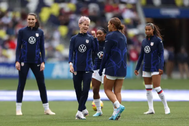 Five female footballers warming up on the pitch