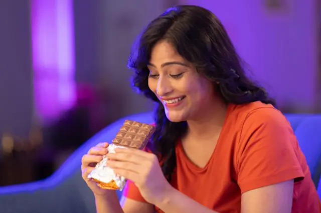ਚਾਕਲੇਟ ਖਾਂਦੀ ਮਹਿਲਾ