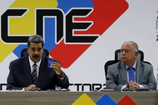 Foto mostra Maduro e Amoroso sentado5.5 1xbetmesa no CNE