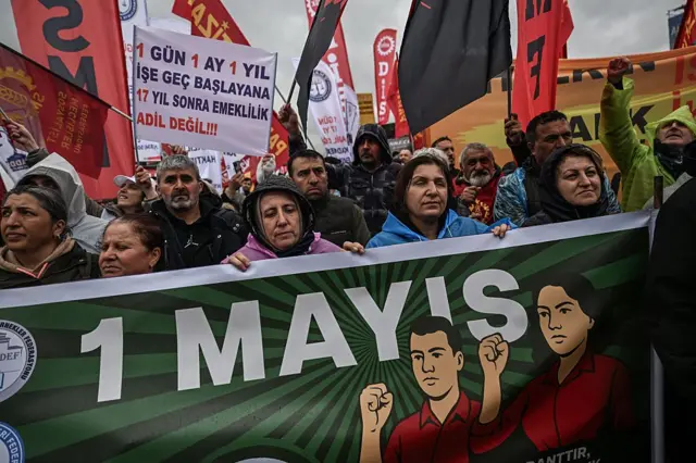 İşçiler ellerinde 1 Mayıs pankartı taşıyor