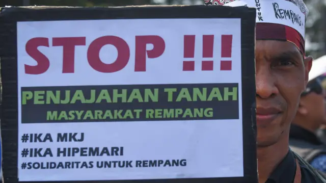 Seorang pengunjuk rasa membawa poster tuntutan dalam Aksi Bela Rempang di kawasan Patung Arjuna Wiwaha, Jalan Medan Merdeka Barat, Jakarta, Rabu (20/9/2023).