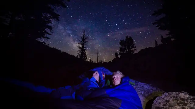 खुले आसमान तले सोते दो लड़के
