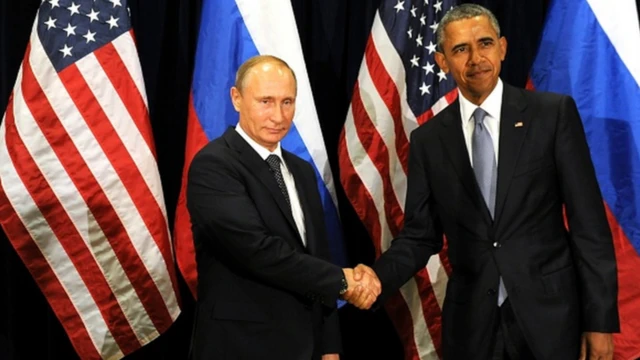 Putin ve Obama, Amerikan bayrağının önünde el sıkışıyor.