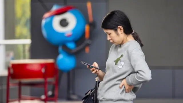 Mujer junto a la mascota del Grupo Hormiga.