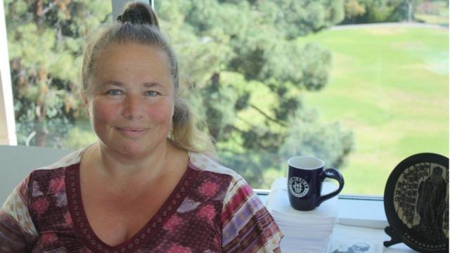 Svetlana Jitomirskaya sorrindo contidamenteesports battlefrente a área verde