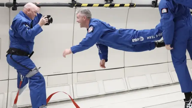 무중력 상태로 공중에 떠서 카메라를 보고 있는 맥폴