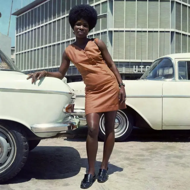 Cette photo prise par James Barnor en 1971 montre une vendeuse à Accra, cela montre l'évolution du style durant sa carrière du Ghana à Londres
