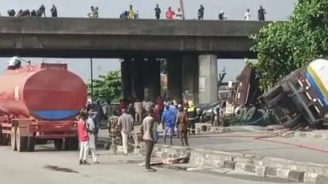 Ibi ọkọ elepo kan subu si, ti ọpọ ero pọ si lati woran, ọkọ elepo miran duro si ẹba oju popo naa.